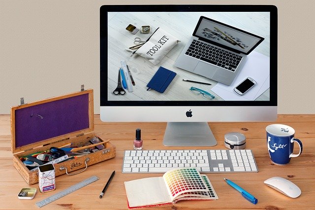 Ein Schreibtisch auf dem ein Computerzubehör, ein Becher und diverser Bürobedarf zu sehen ist.